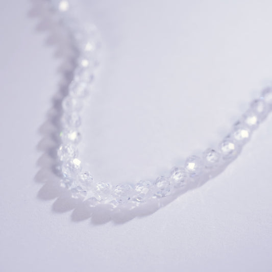 Close-up of the Morning Light Necklace laid on a light purple surface, showing faceted CZ clarity and minimalist Korean design by GinaKimKR.