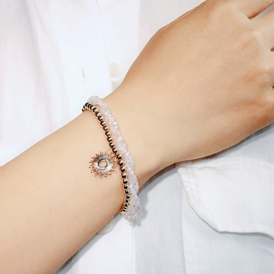 GinaKim Blush Prism Bracelet worn on wrist, featuring soft rose gold and translucent crystal quartz beads with a radiant gold charm for a feminine, elegant look.