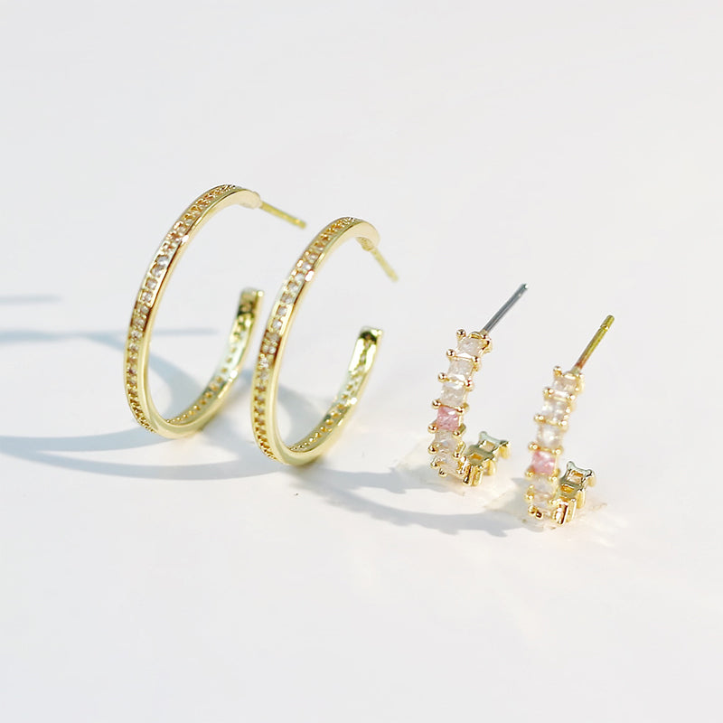 Side angle view of three gold-tone earrings from Blush Beam Set, highlighting curved and minimalist designs.