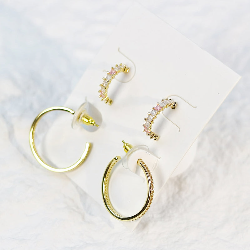 Blush Beam earrings styled on a soft fabric surface, showcasing gentle shine and rose gold details in natural light.