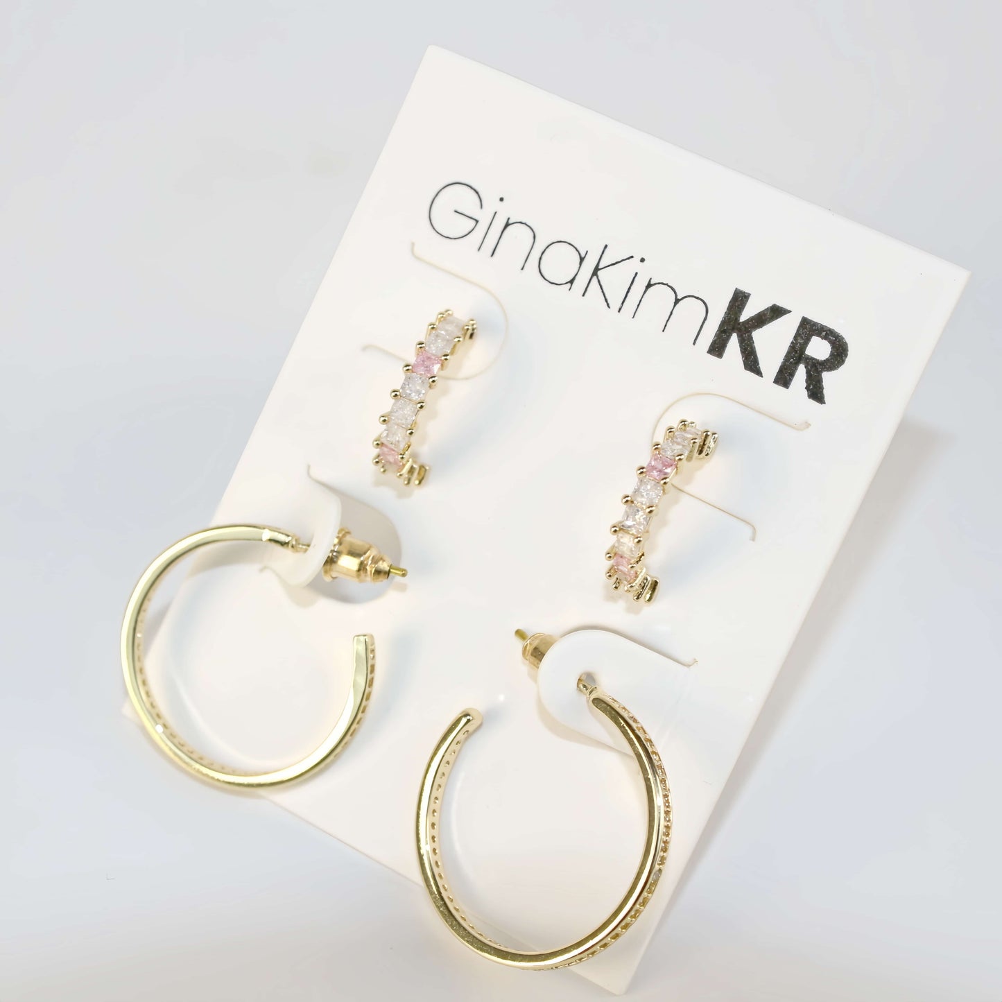 Flat lay of GinaKimKR Blush Beam Set with circular and bar-shaped gold earrings arranged elegantly for product detail.