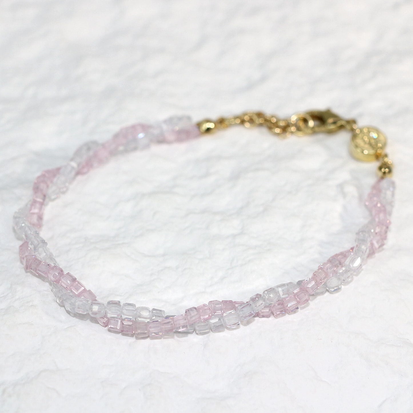 A close-up of the Blush Prism Bracelet, showcasing warm champagne-pink crystal beads with a luminous finish. The stretch bracelet features a sparkling CZ accent bead, styled on a woman’s wrist with soft natural lighting for an elegant, feminine look.