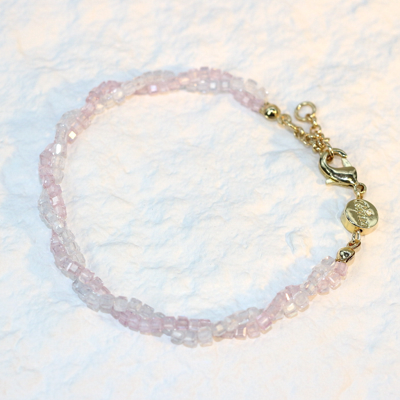 A close-up of the Blush Prism Bracelet, showcasing warm champagne-pink crystal beads with a luminous finish. The stretch bracelet features a sparkling CZ accent bead, styled on a woman’s wrist with soft natural lighting for an elegant, feminine look.