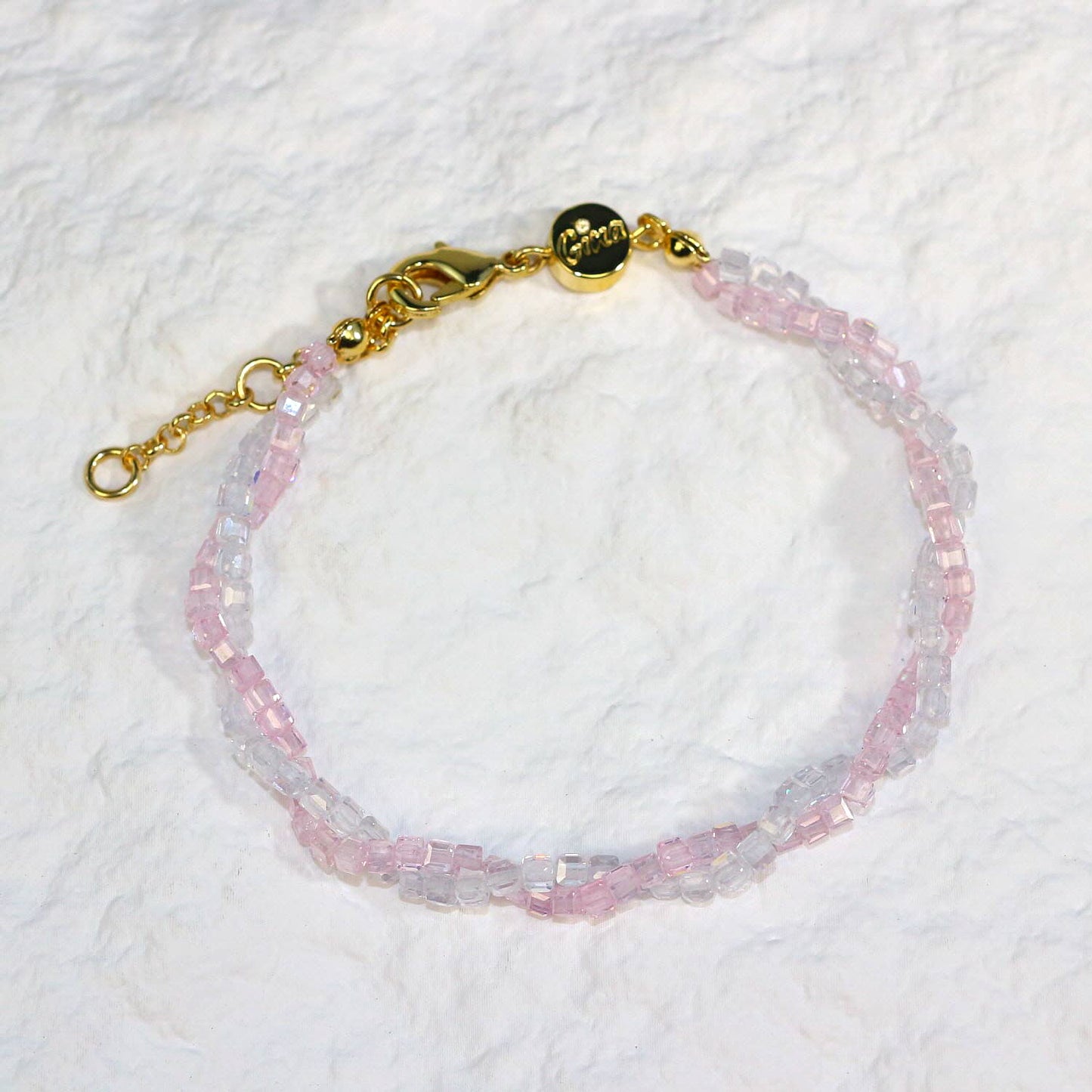 A close-up of the Blush Prism Bracelet, showcasing warm champagne-pink crystal beads with a luminous finish. The stretch bracelet features a sparkling CZ accent bead, styled on a woman’s wrist with soft natural lighting for an elegant, feminine look.
