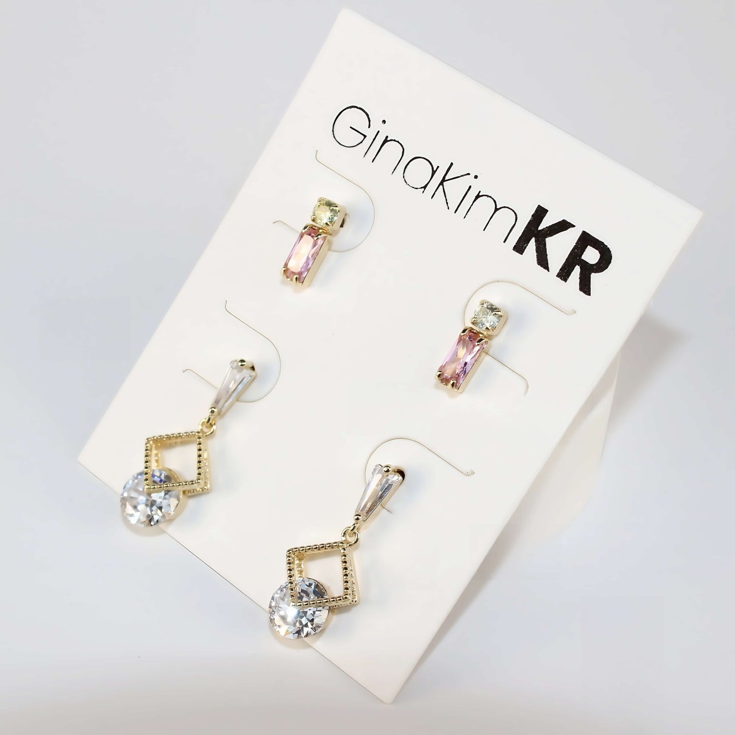 Vertical display of the three-piece Dewlight Earring Set showing different earring lengths, with minimal natural background.