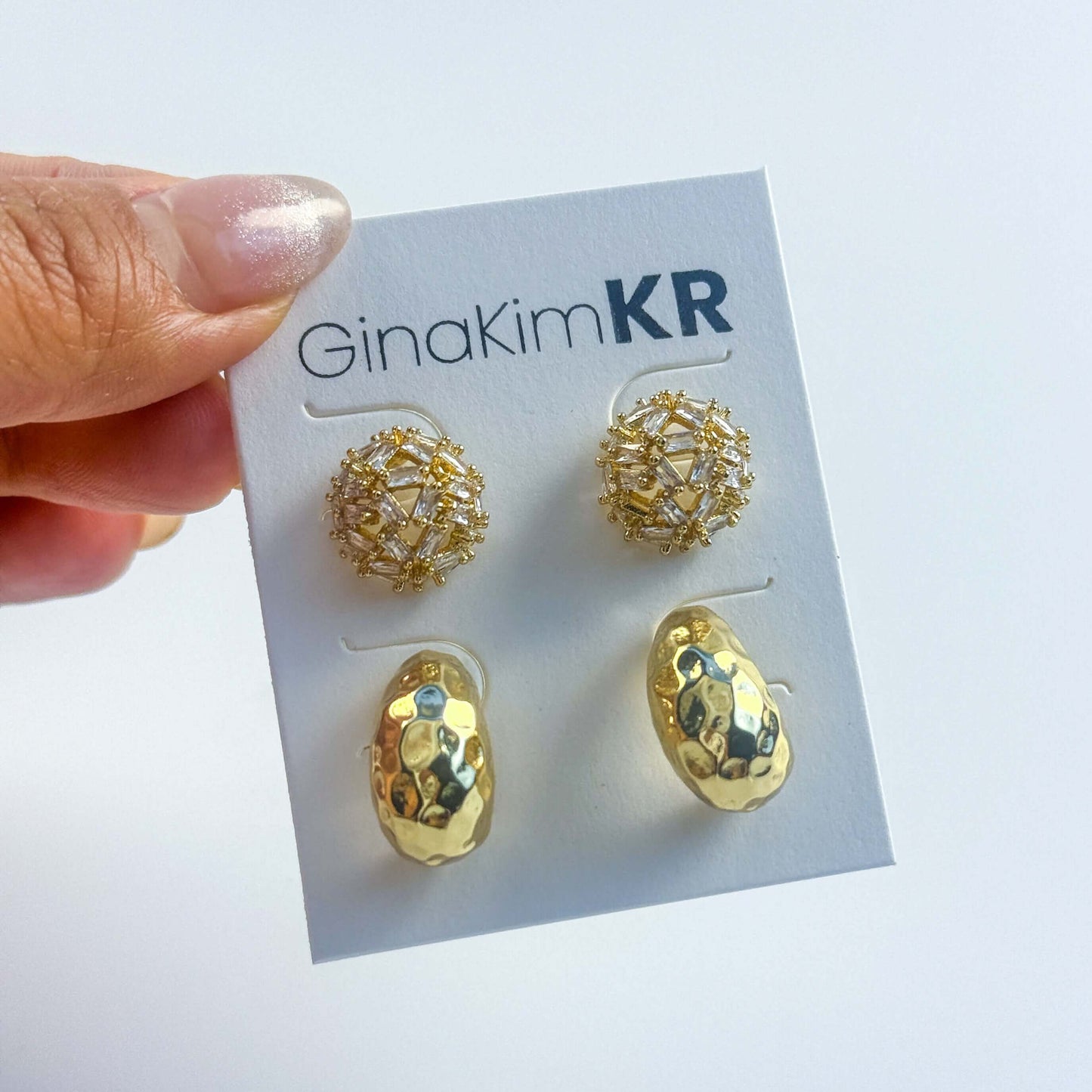 Hand holding GinaKimKR Golden Radiance Earring Set. Shows lightweight size and refined packaging for gift-ready presentation.