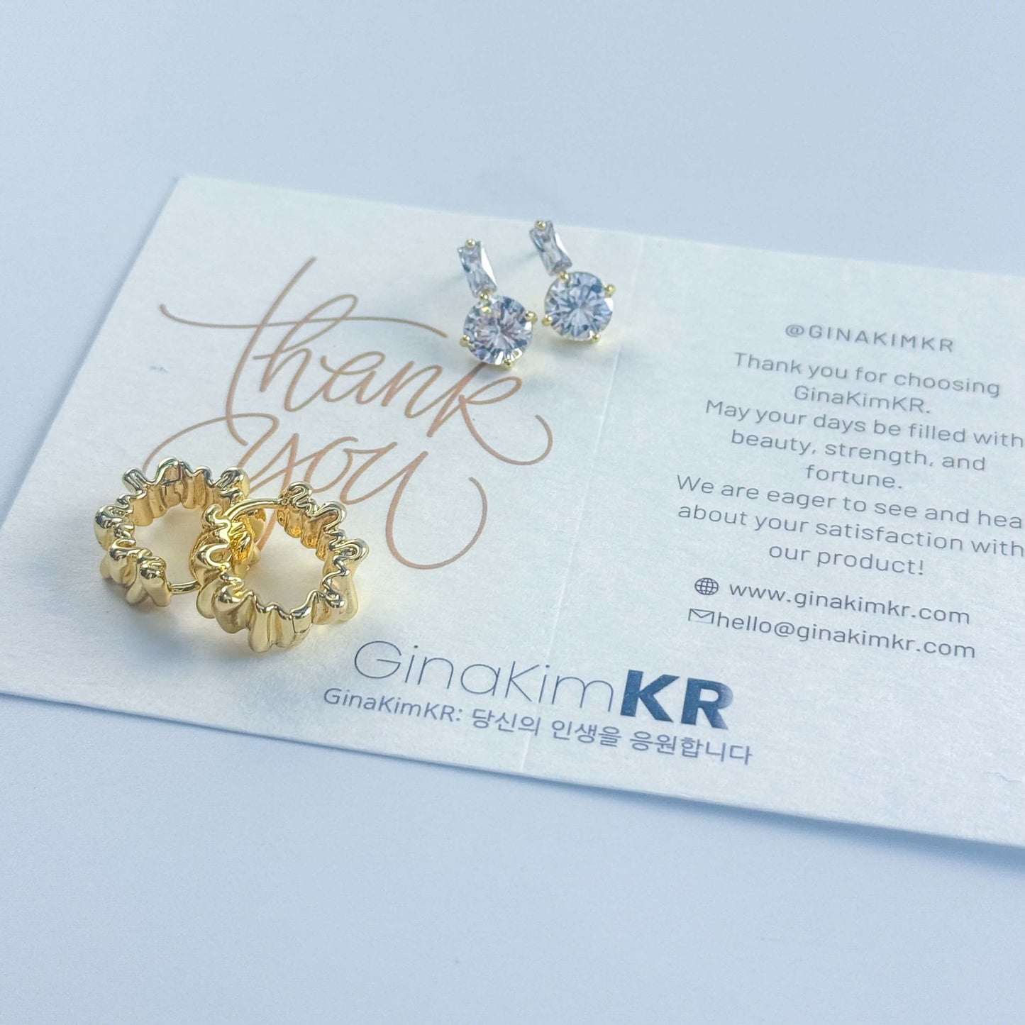 GinaKimKR’s Gleam Ripple Earring Set shown with brand care and message card, combining sparkle and thoughtful presentation.