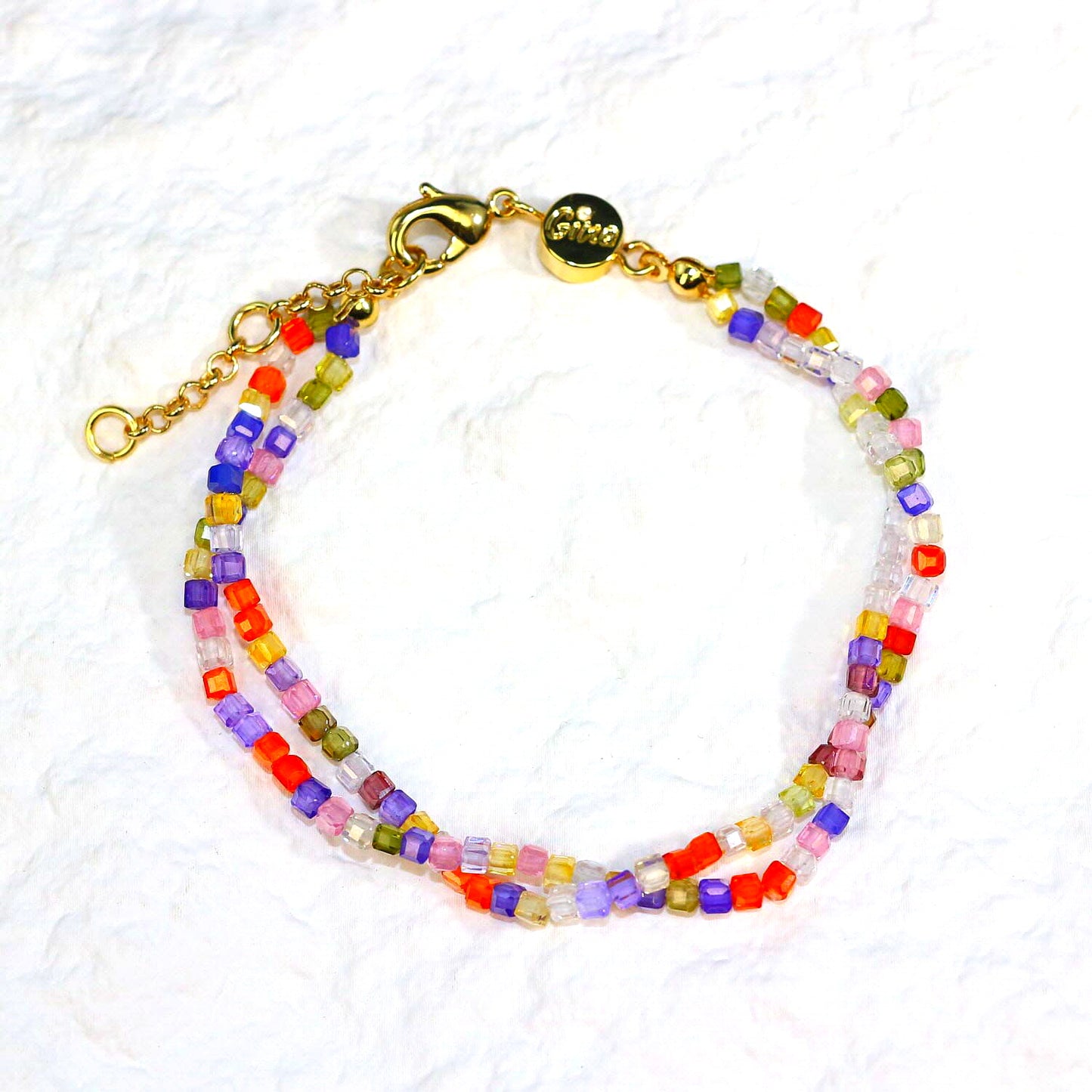 A close-up of the Joy Prism Bracelet featuring soft blush-toned crystal beads with a subtle iridescent sheen. The bracelet is stretch-fit and accented with a delicate CZ bead, styled elegantly on a woman's wrist in natural sunlight.
