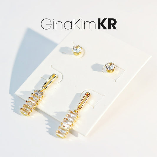 Lightfall Duo Earring Set by GinaKimKR displayed on branded card, featuring two pairs of gold-tone minimalist earrings.