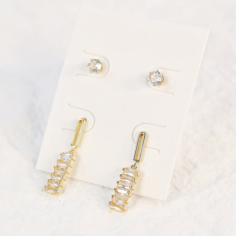 Flat lay of GinaKimKR Lightfall Duo Earring Set showcasing clean-lined geometric styles in warm gold finish.