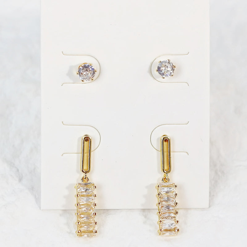 Close-up of Lightfall Duo gold earrings with bar and drop designs, arranged vertically on a clean white background.