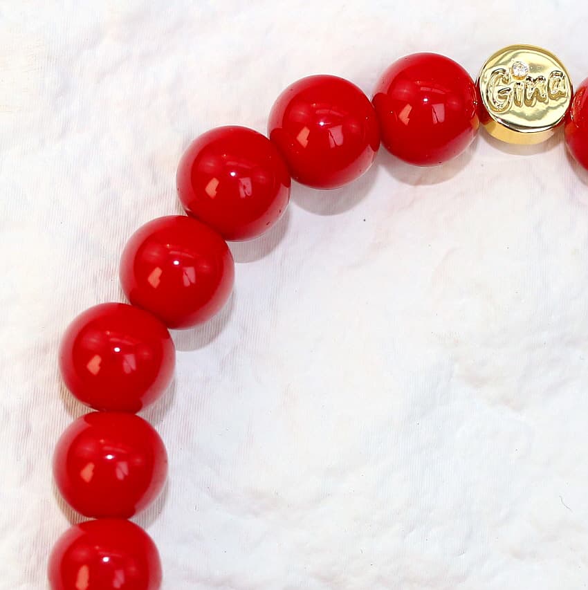 Close-up angle of the Red Jasper Strength Bracelet showing polished 8mm red jasper stones with smooth surface detail, highlighting its bold unisex design.