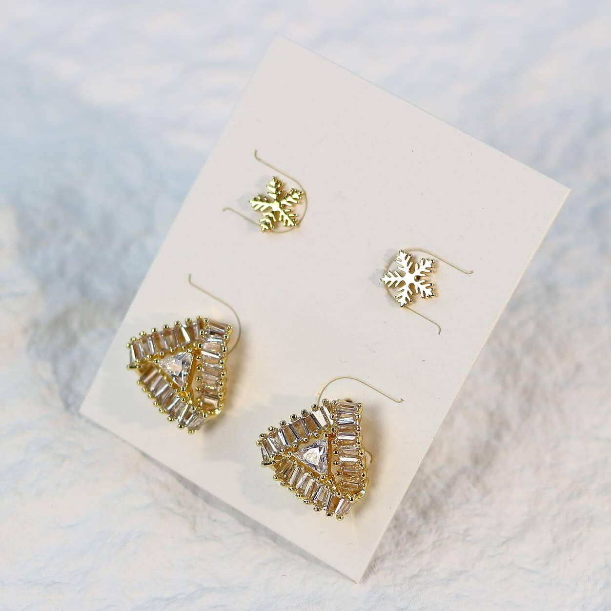 Top view of Snow Prism Earring Set featuring three pairs of gold-tone crystal studs on a white card.