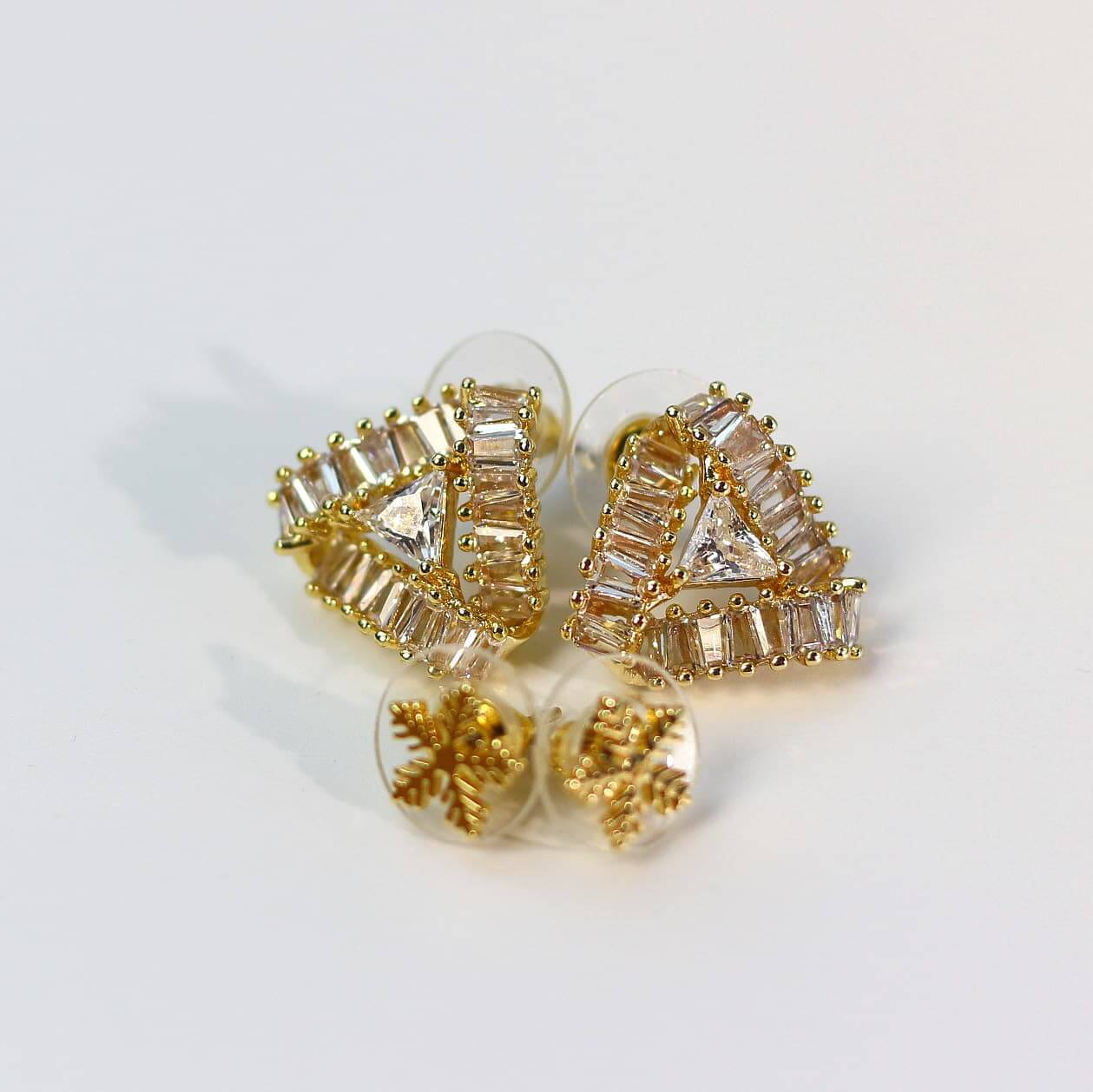 Close-up of gold-tone floral crystal stud earrings with faceted multi-prism texture from Snow Prism Set.
