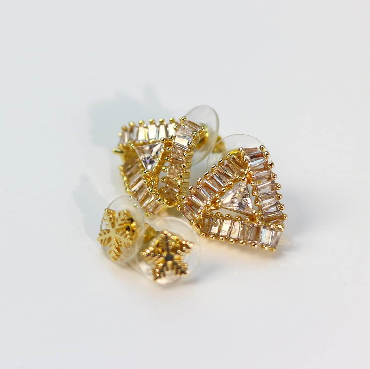 Side-angle image of clustered clear and golden CZ studs with snowflake-inspired sparkle effect.