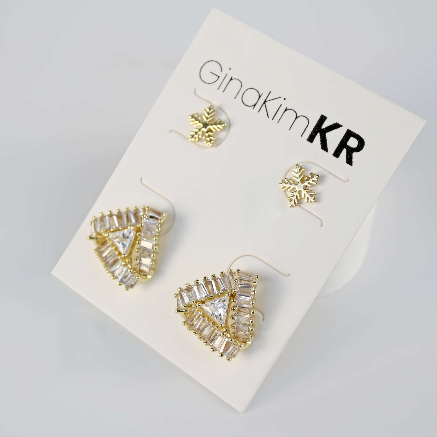 Snow Prism earrings laid out with three different shapes including stars and clustered studs on display card.