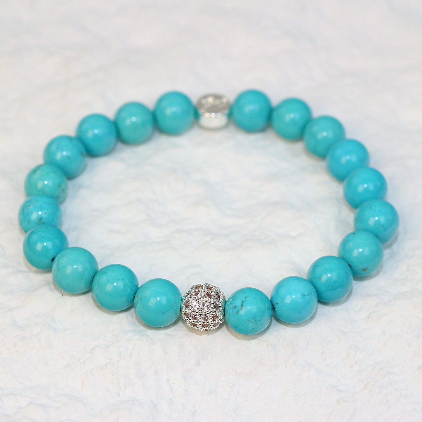 Angled view of the Turquoise Strength Bracelet with polished 8mm beads showing subtle natural patterns, crafted for everyday unisex wear.