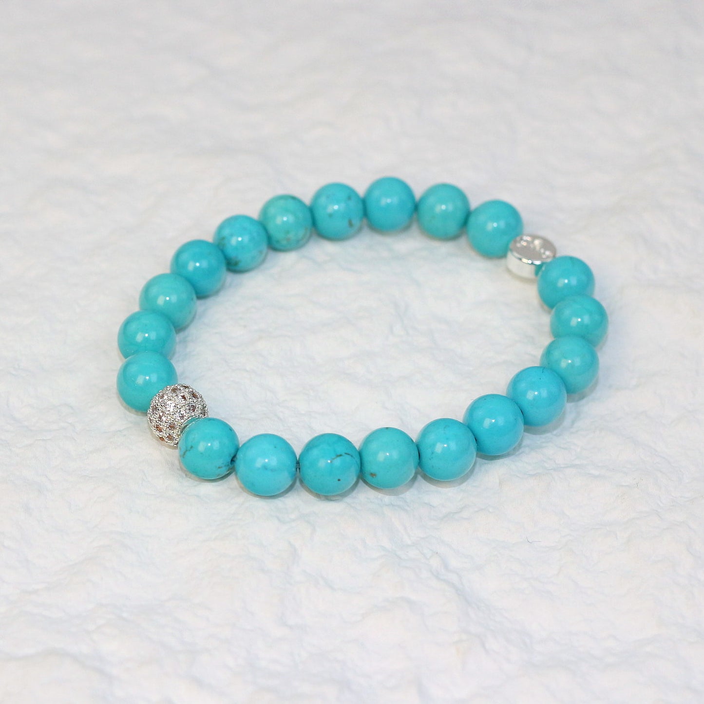 Top-down image of the Turquoise Strength Bracelet featuring 8mm round beads in vibrant sky blue, arranged in a circle on a white background.