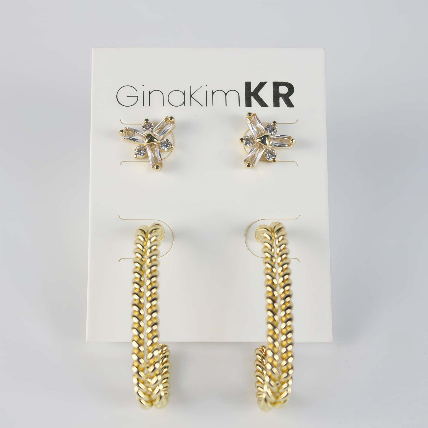Front view of gold twist hoop earrings and CZ floral studs on GinaKimKR card – Twist Bloom Earring Set