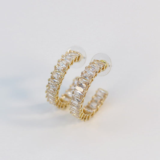 Celeste Crown Hoop Earrings with 28mm gold hoops fully set with 3×5mm baguette-cut CZ stones, shown on white background.