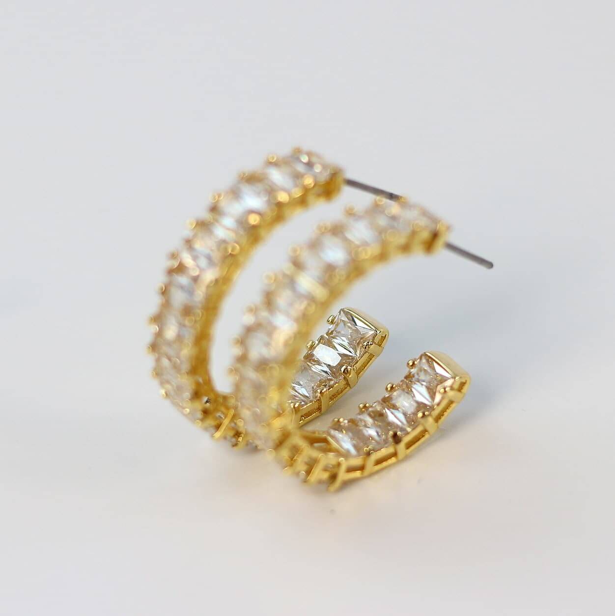 Zoomed view of CZ baguette-cut stones on Celeste Crown Hoop Earrings.