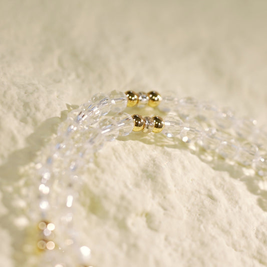 Close-up of the Clarity Duo Bracelet by GinaKimKR showing faceted quartz beads, gold spacers, and signature logo tag. Crafted for a refined, luminous look.