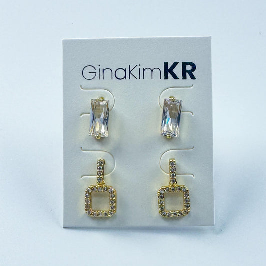 Flat front-facing view of GinaKimKR Crystal Edge Duo Earring Set featuring sparkling geometric gold drop earrings and studs