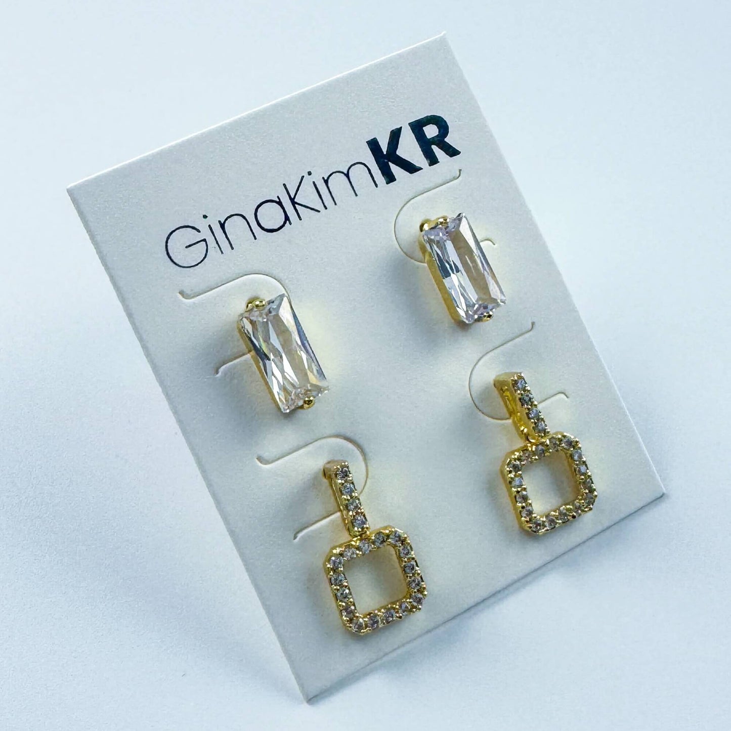 GinaKimKR logo and Crystal Edge Duo Earrings set in angled display with CZ detailing and crystal studs