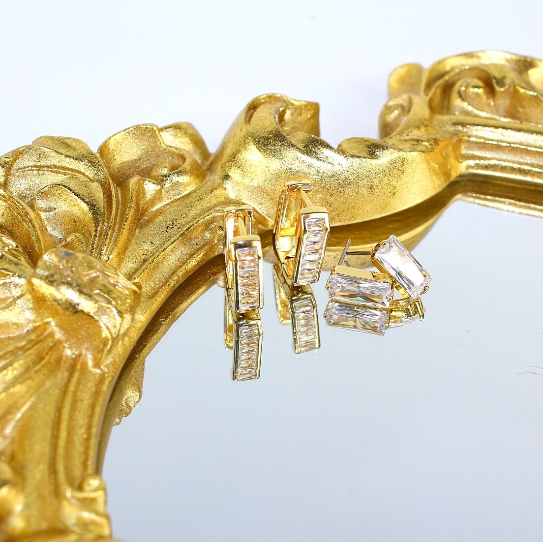 Crystal Line Duo earrings by GinaKimKR hanging on gold-framed mirror – elegant geometric sparkle