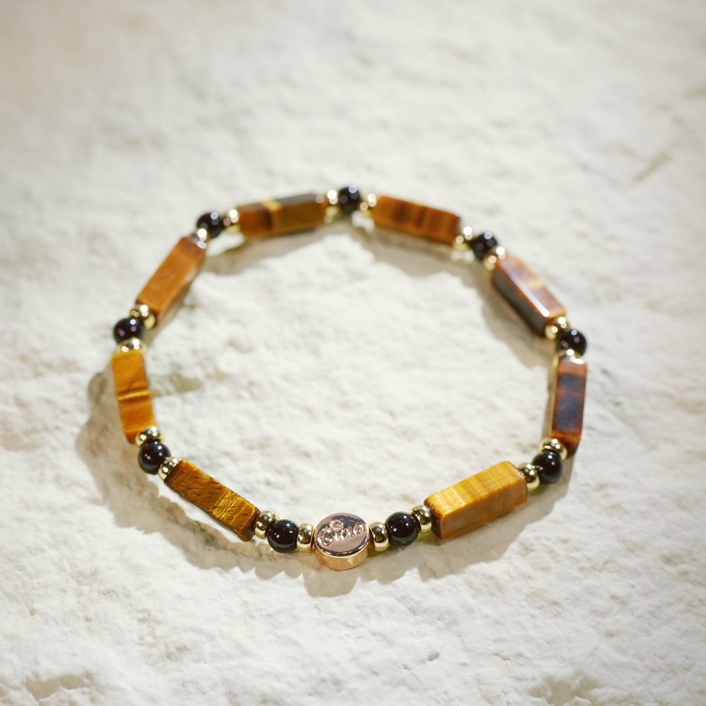 GinaKim Focus Strength Bracelet featuring natural Tiger's Eye and Onyx beads, with gold-plated accents and a stretch design for a luxurious, empowering look