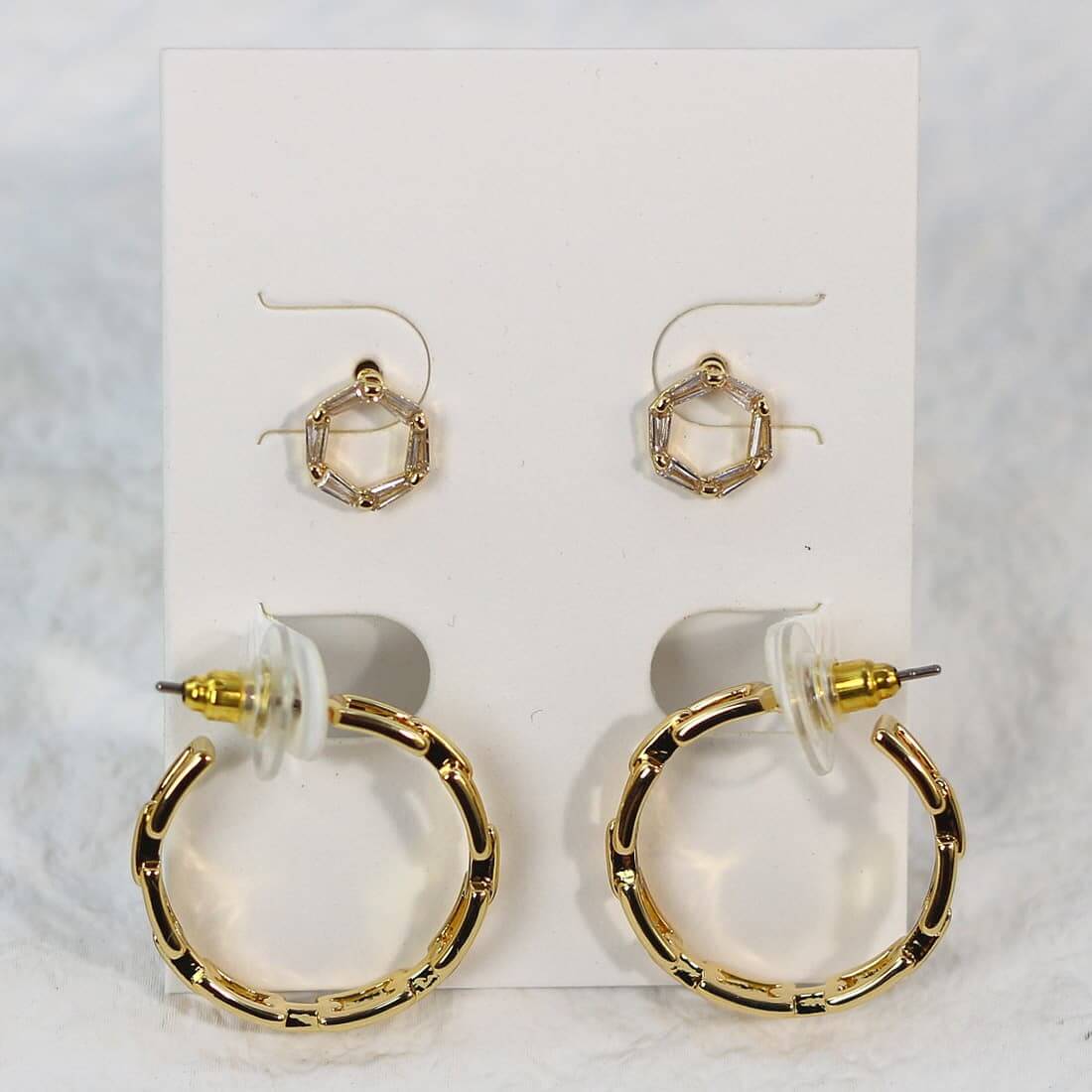 Front-facing card display of Geo Spark Earrings with octagon CZ studs and gold hoops with artistic cut-out detail and trapezoid accents.