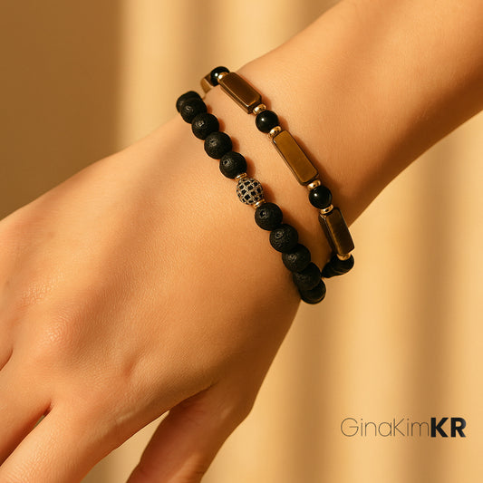 Stacked GinakimKR Focus Strength Bracelet (Tiger's Eye, Onyx, Gold-plated) and Lava Fortune Bracelet worn on a wrist. A powerful combination for courage, grounding, and good fortune in unisex style
