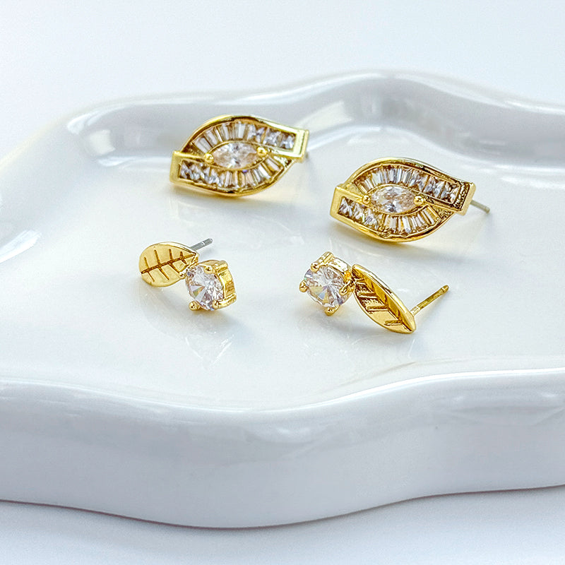 Full set of GinaKimKR gold-tone leaf earrings with various CZ cuts arranged side by side for product detail.