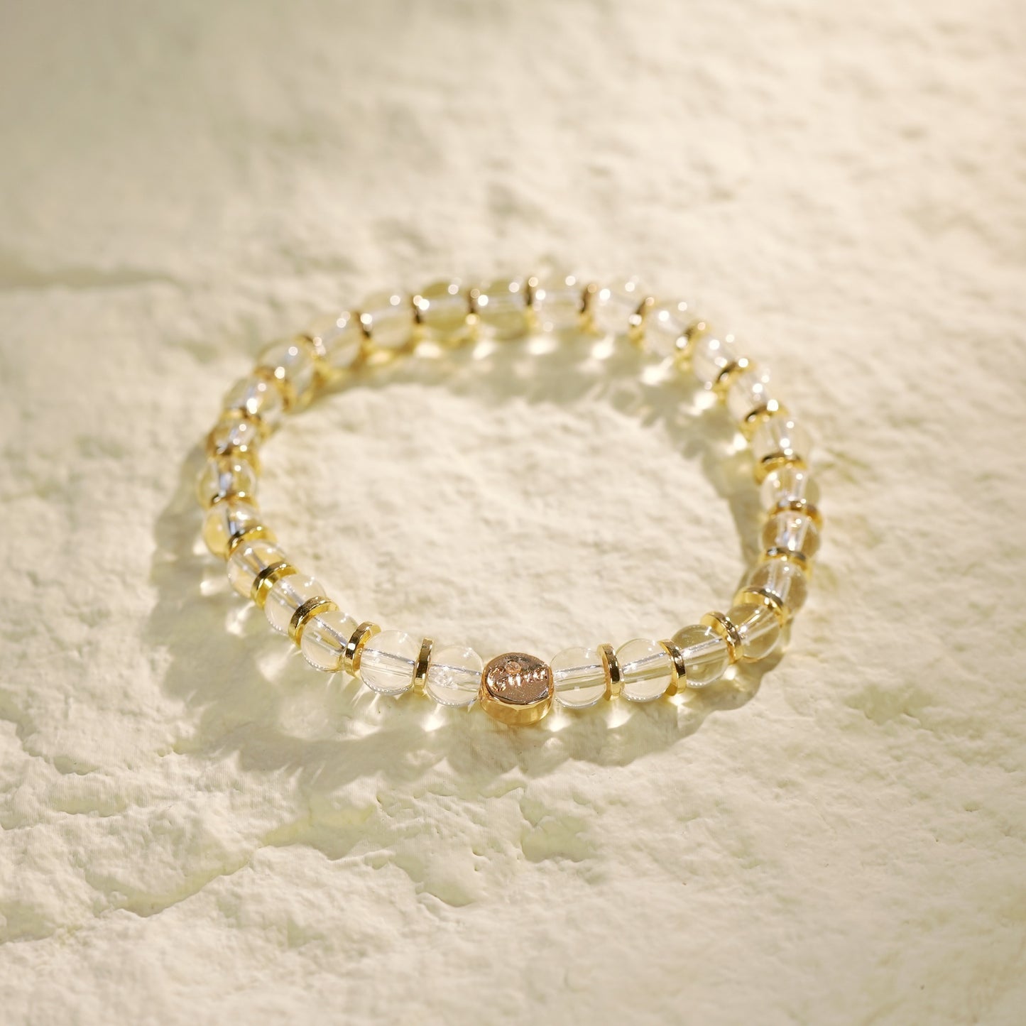 Handcrafted crystal quartz bracelet with gold-toned elements. Symbol of inner clarity and quiet sophistication by GinaKimKR.