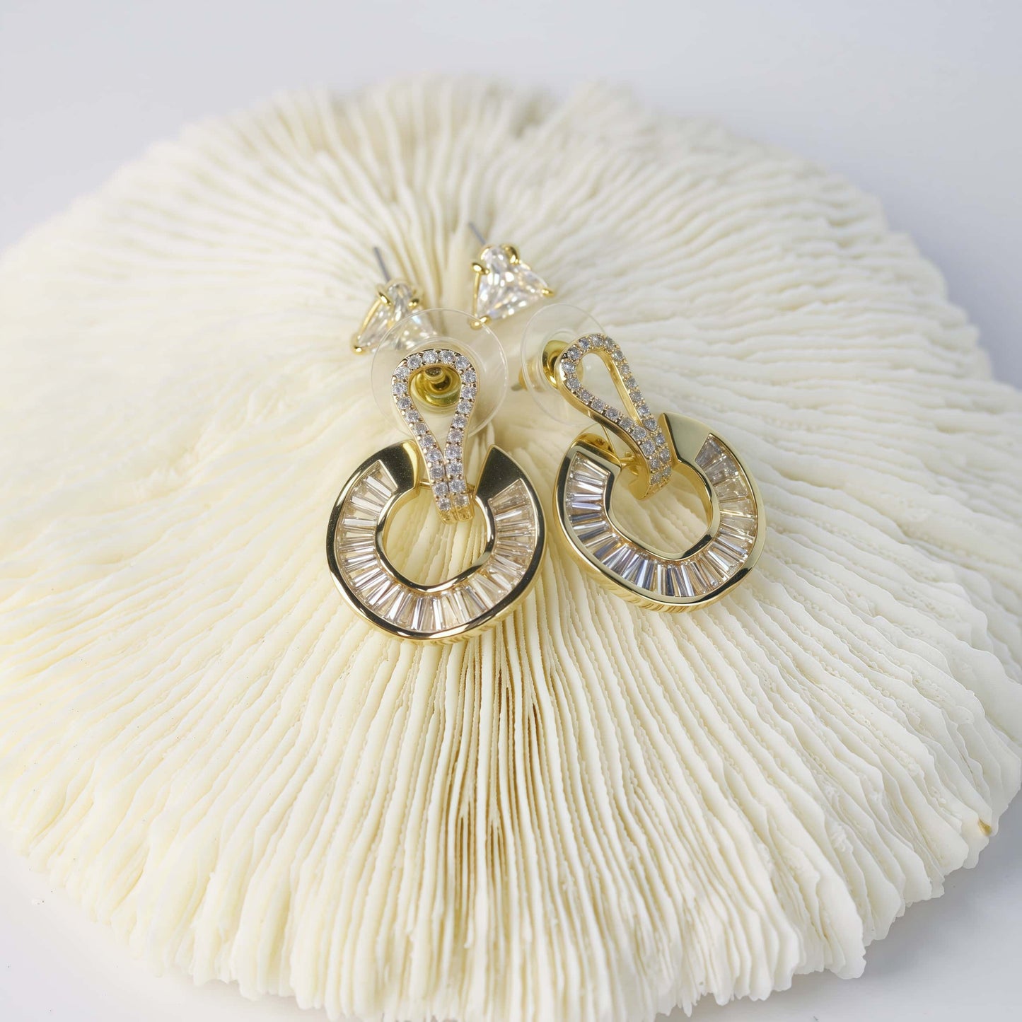 Top view of GinaKimKR’s Golden Edge Duo earrings, showing CZ triangle studs and gold crystal loops