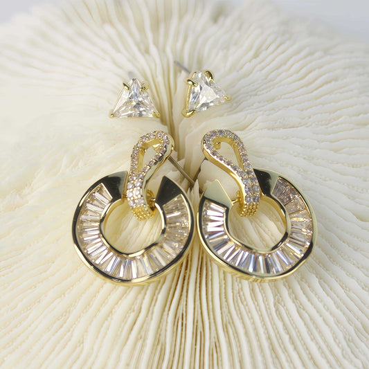 Gold loop drop earrings with baguette-cut crystals from the Golden Edge Duo set, displayed on soft cream fur background