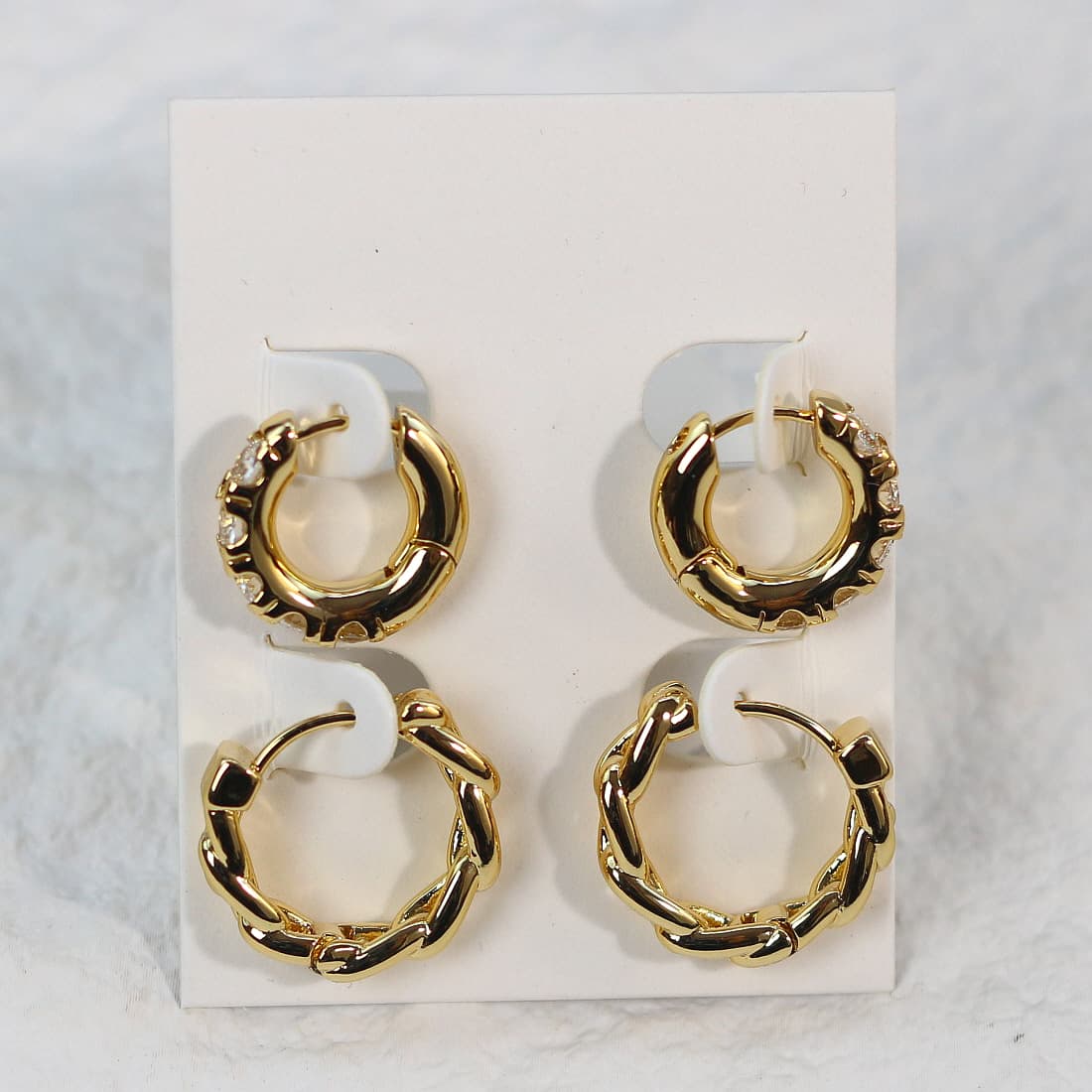 Symmetric front-facing view of Golden Gleam Huggie Set with variety of hoop designs—bold, sleek, braided, and crystal-accented—on a white card.