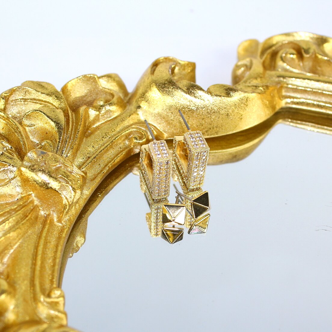 Golden Structure earrings styled on ornate gold-framed mirror – modern luxury look