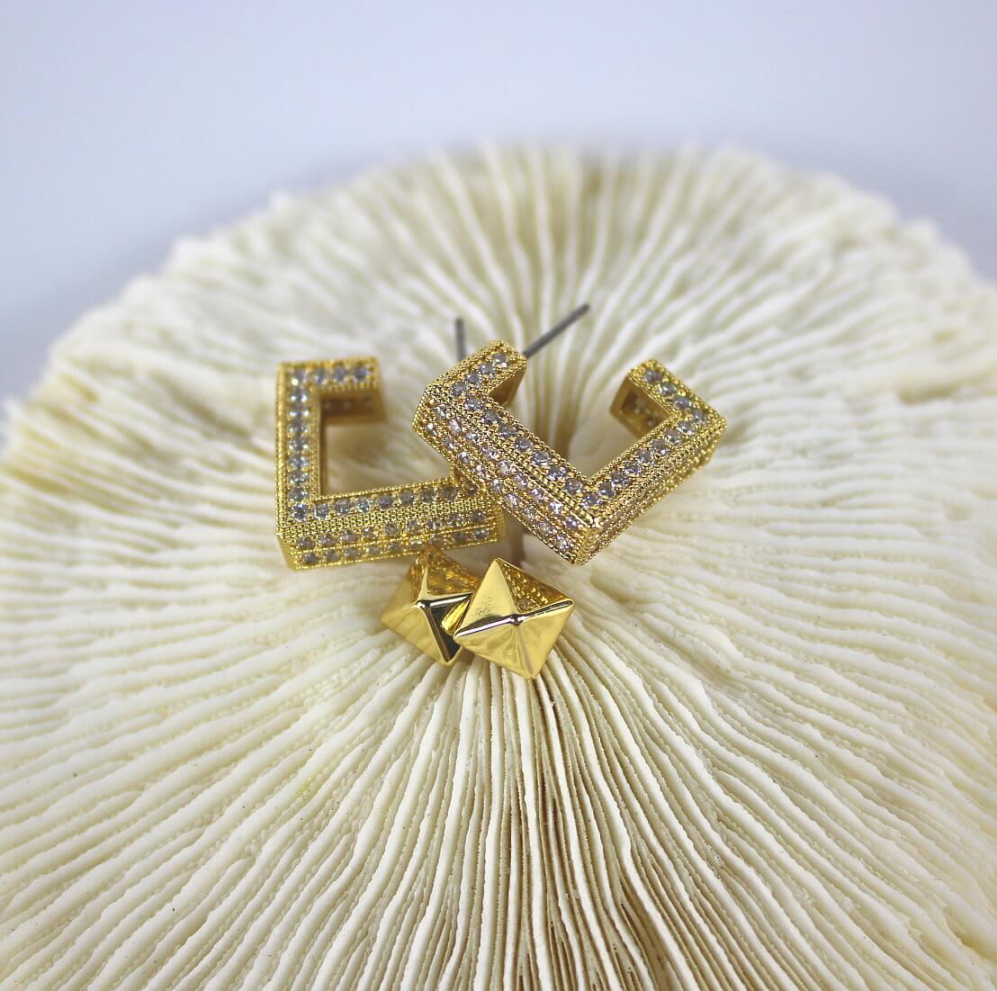 Top view of Golden Structure Set earrings – pyramid studs and square CZ hoops side by side