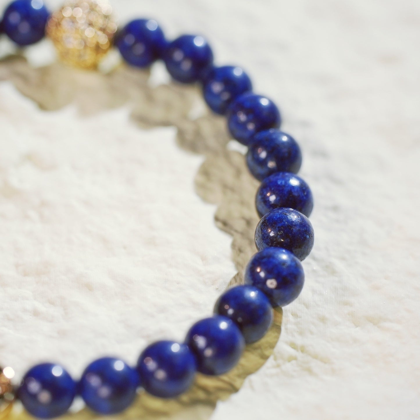 Close-up of the Lapis Lazuli Fortune Bracelet showing polished deep blue stones, a CZ accent, and signature GinaKimKR charm. Designed for clarity and focus.