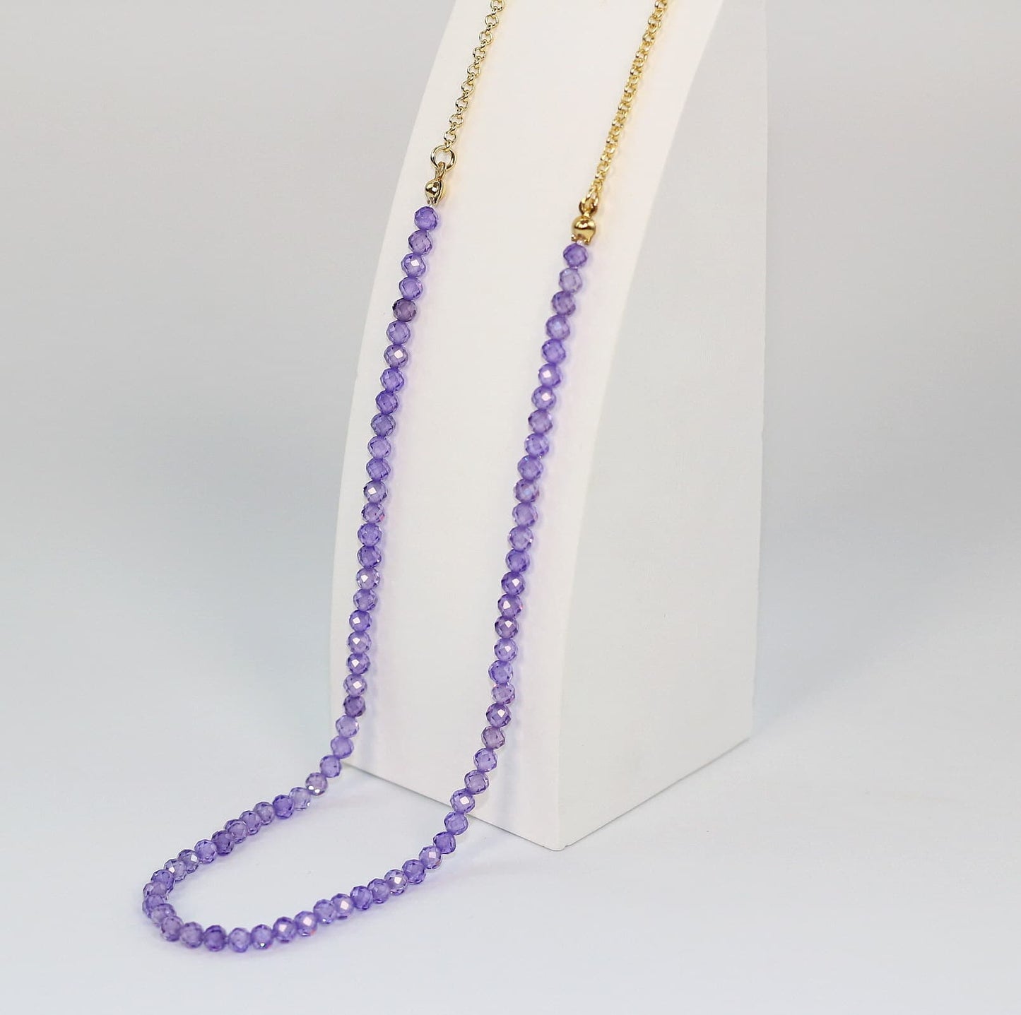 Close-up of sparkling 4mm purple CZ beads on the Lavender Light Necklace, showing detailed texture and color.
