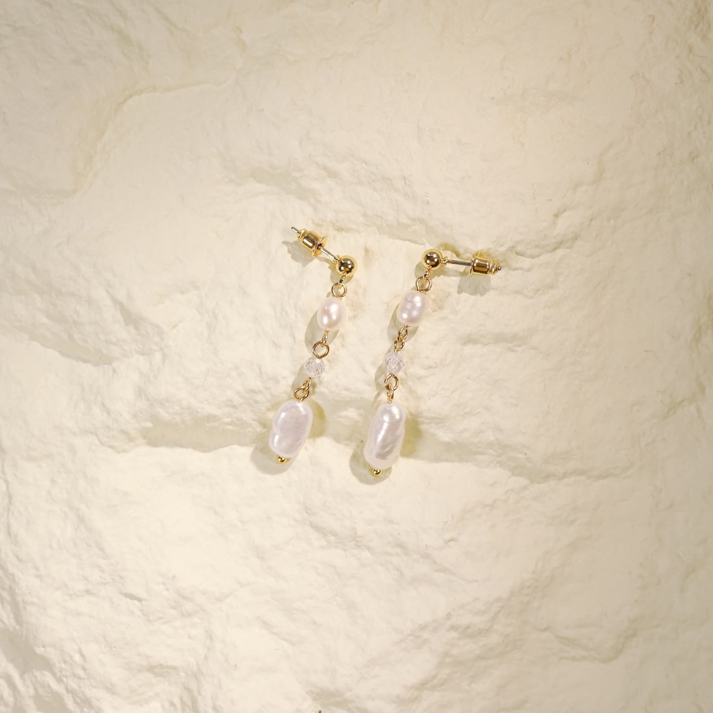 Top-down close-up of Golden Drop Baroque Pearl Earrings featuring faceted crystal details and irregular pearls, highlighting their unique handmade design.