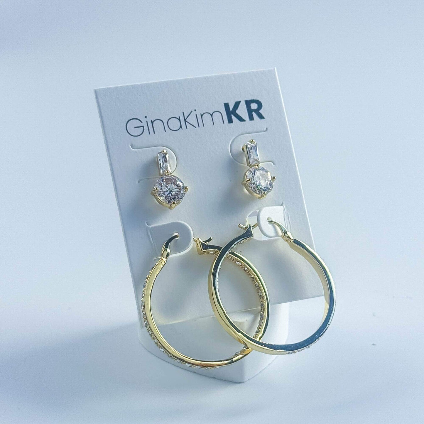 Front view of GinaKimKR Luna Spark Earring Set with pavé gold hoops and round CZ drop studs on display card