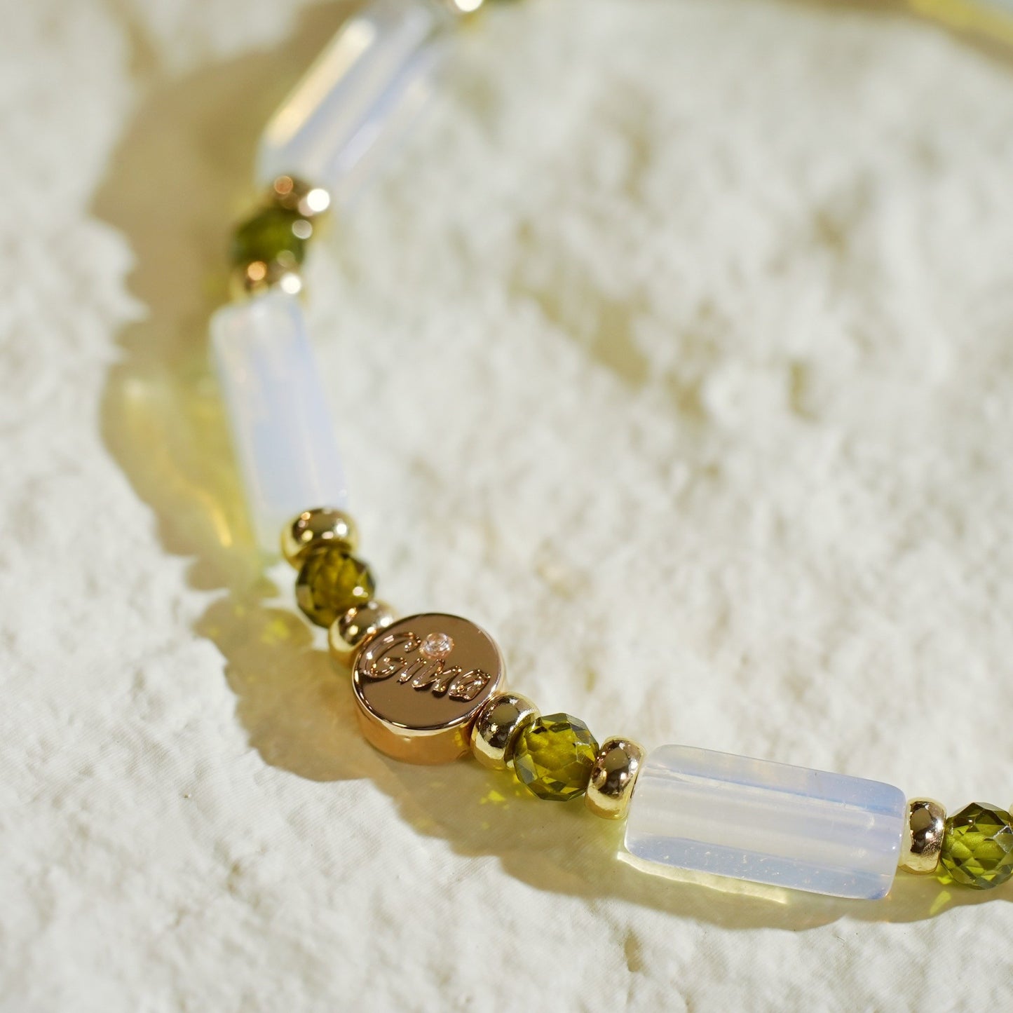 Close-up of the Lunar Light Stretch Bracelet showing moonstone’s natural luster, gold accents, and deep green CZ detailing. Calm and elegant design by GinaKimKR.