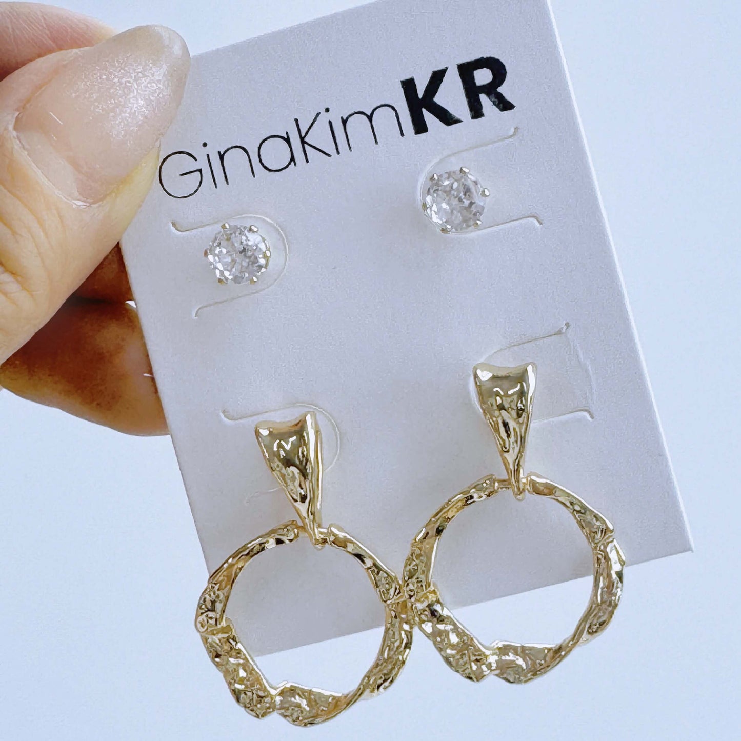 Close-up handheld shot of GinaKimKR Molten Circle Earring Set showing gold hoop texture and sparkle of CZ studs