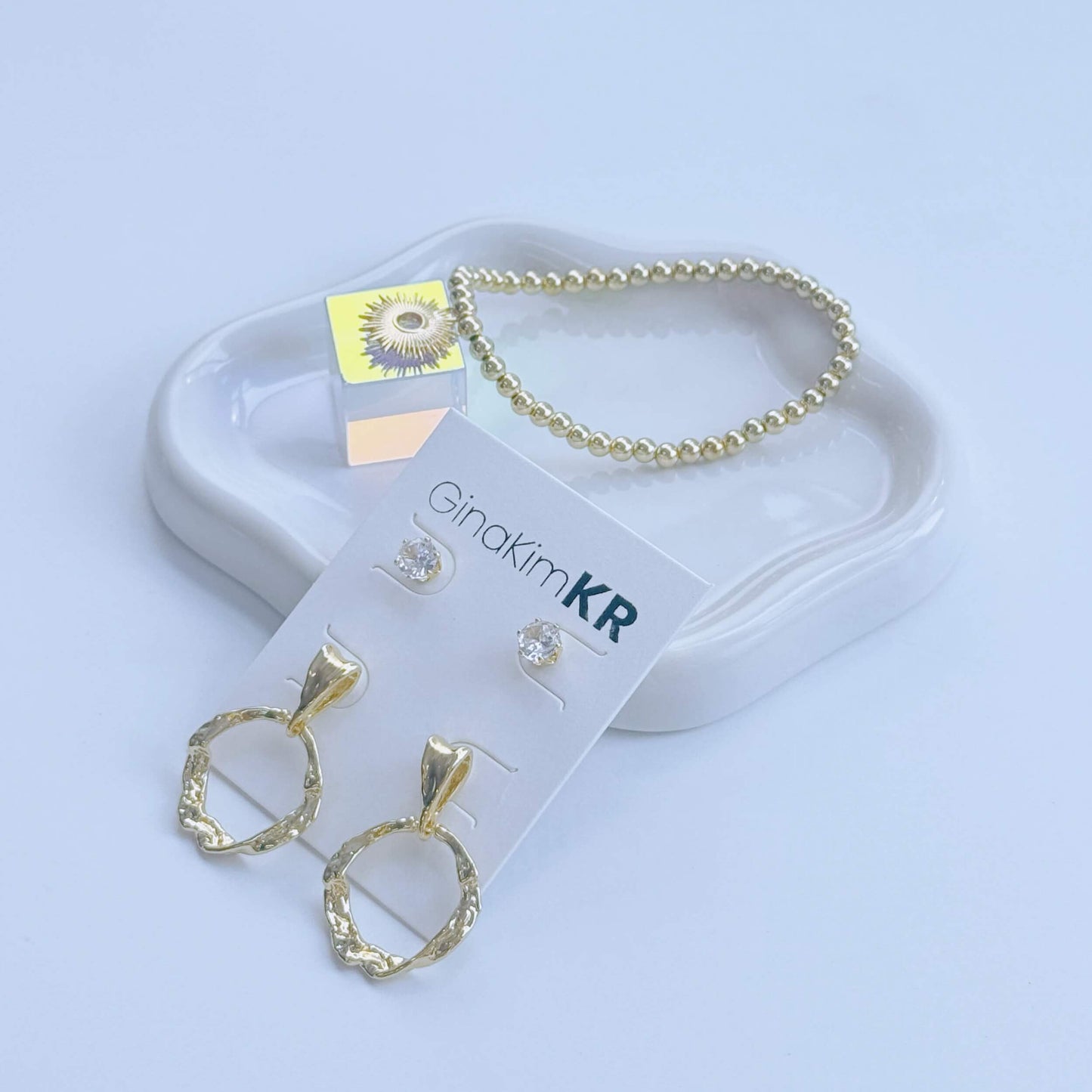 Coordinated jewelry flat lay featuring GinaKimKR Molten Circle Earring Set and gold bracelet