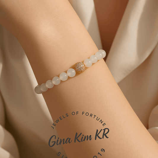 A person wearing the Moonstone Fortune Bracelet by GinaKimKR. The iridescent moonstone and gold detailing bring elegance and emotional harmony.