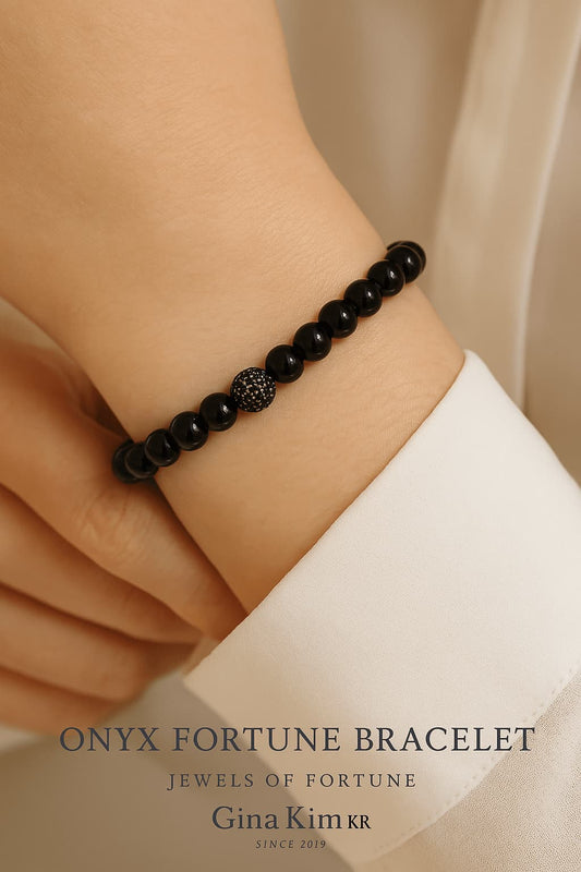 A woman wearing the Onyx Fortune Bracelet by GinaKimKR, featuring polished onyx stones with a silver CZ bead and signature charm. Strong, minimal, and stylish.