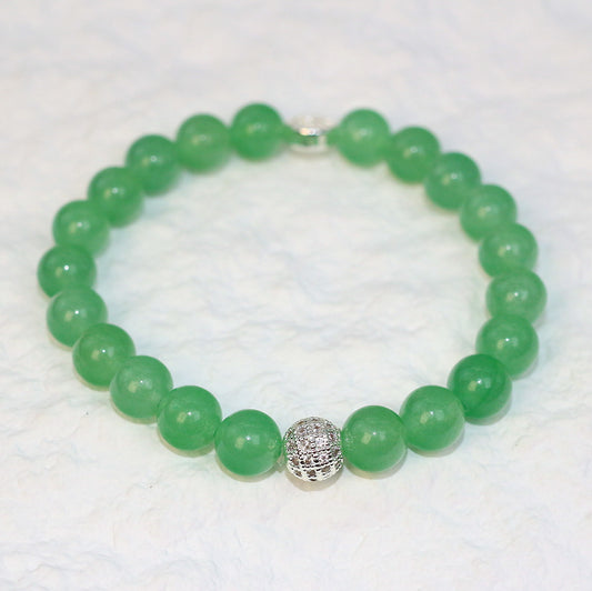 Angled flat-lay of the Peridot Strength Bracelet with translucent green beads, symbolizing renewal, focus, and harmony in a unisex design.