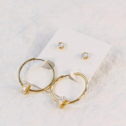 Radiant Harmony Earring Set displayed on a cream-colored card, featuring 30mm gold hoops with crystal accents and 6mm CZ stud earrings.